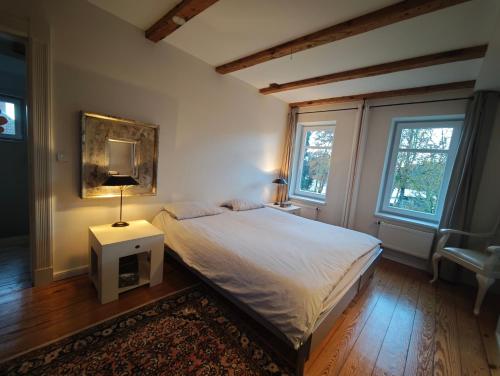 a bedroom with a bed and a table with a lamp at Trentsee Chalet in Malente