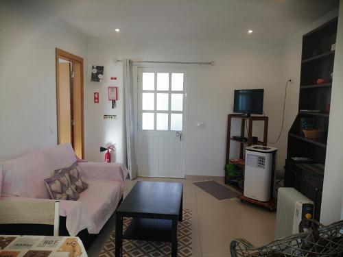 a living room with a couch and a tv at Quinta do Medronhal Faro - casas de férias medronhal in Faro