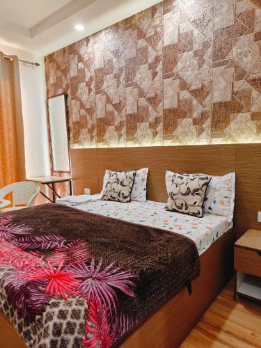 a bedroom with a large bed with a wall at Kaveri splendid apartment in Greater Noida