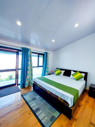 a bedroom with a large bed with blue curtains at The Valley View Homestay in Lansdowne