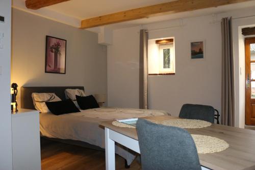 a bedroom with a bed and a table and chairs at L'Autan sage in Montgeard
