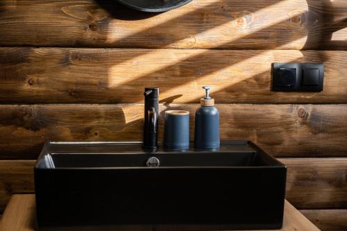 a black bathroom sink with a soap dispenser on it at Barn&Haus-Stodoły Widokowe in Zubrzyca Dolna