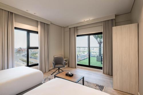 ein Schlafzimmer mit Bett, Stuhl und Fenstern in der Unterkunft Karim Hotel in Dammam