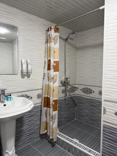 a bathroom with a shower and a sink at Al-Adl Guest House in Bukhara