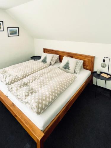 a bedroom with a large wooden bed with pillows at Chata Hella in Pernink