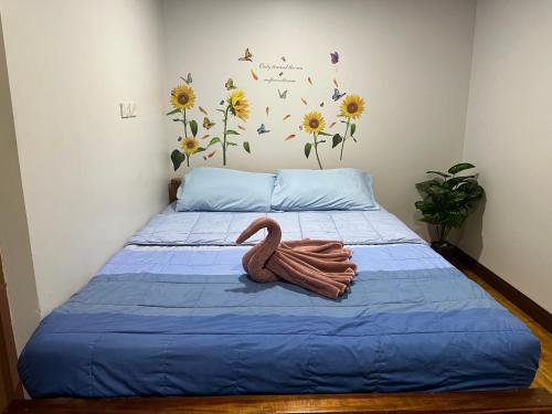 a swan sitting on a bed in a bedroom at Kohpu garden in Ban Klang