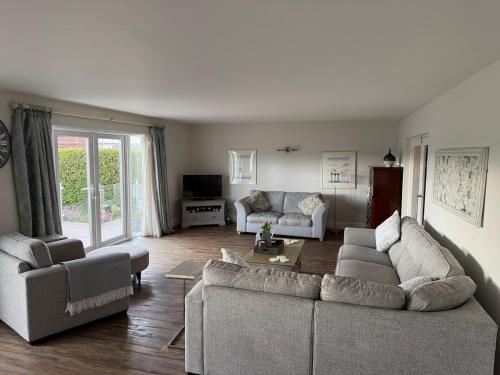 a living room with two couches and a table at The Cherries in Penrhyn Bay