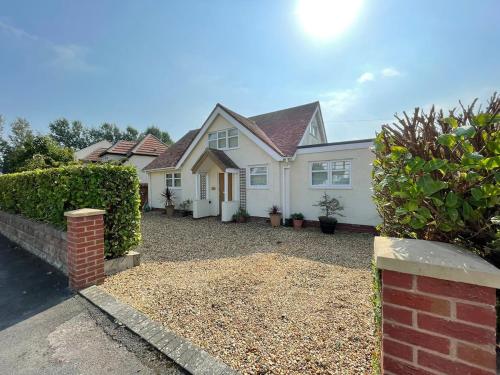 a white house with a brick fence at The Cherries in Penrhyn Bay