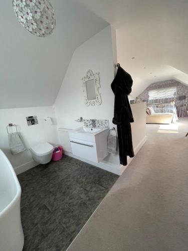a white bathroom with a sink and a toilet at The Cherries in Penrhyn Bay