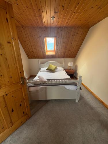 a bed in a room with a wooden ceiling at Ashmore Mews in Galway