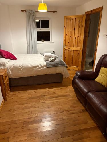 a bedroom with a bed and a couch at Ashmore Mews in Galway