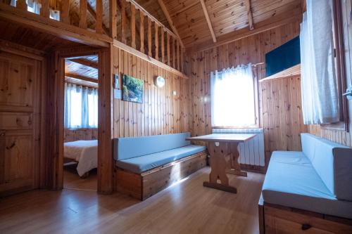 a room with a bench and a bed in a cabin at La Borda del Pubill Resort in Ribera de Cardós