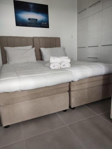 a bed with two towels on it in a bedroom at By the wave luxurious studios in Piraeus