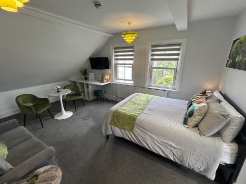 a bedroom with a bed and a chair and a desk at Rivendell Holiday Studios & Suite in Swanage
