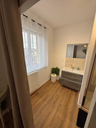 a bathroom with a tub and a sink and a mirror at Les meublés de l Etoile in Eu