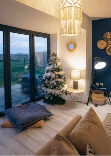 a living room with a christmas tree and a couch at Anglesey sleeps 10 with hot tub in Llanfaelog