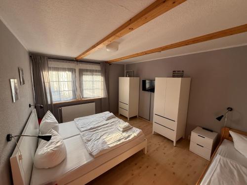 a small bedroom with a bed and a refrigerator at Strandgut- die Große in Dranske