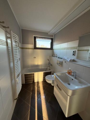 a bathroom with a white toilet and a sink at Strandgut- die Große in Dranske