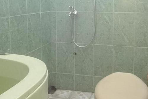 a bathroom with a shower and a toilet and a sink at Bromo Indah Lestari Homestay Mitra RedDoorz in Pasuruan