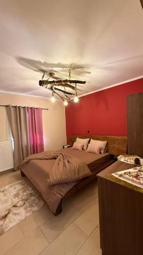 a bedroom with a large bed and a red wall at Kerkini's Harmony House in Kerkini