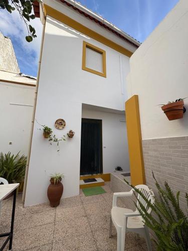 a patio with white walls and white chairs at Casa da Avó Virgínia in Elvas