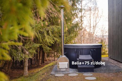 a hot tub with a grill next to a tree at Dom w Starkowie, Sauna i Balia in Starków