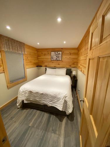 a bedroom with a bed in a wooden room at Cozy stream-side cabin in Lanesborough