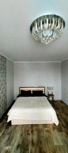 a bedroom with a bed and a chandelier at Рахмет in Petropavlovsk