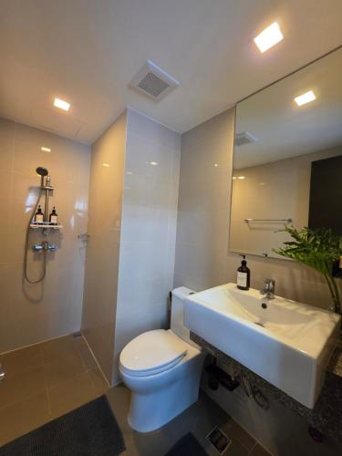 a bathroom with a white toilet and a sink at Two Regis Bacolod Cozy 1BR Condo with Balcony in Bacolod