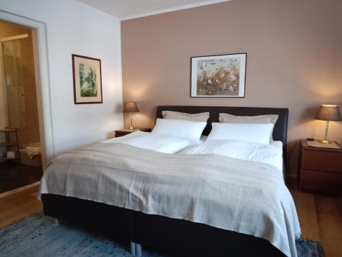 a bedroom with a large bed with white sheets at Gästehaus Nicole in Garmisch-Partenkirchen