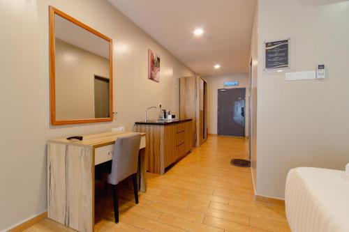 a room with a desk and a bed and a mirror at Bangi Perdana Hotel in Bangi