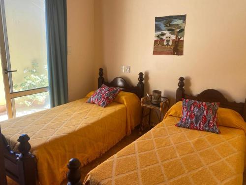 a bedroom with two beds and a window at Cabañas Luna y Sol in Cafayate