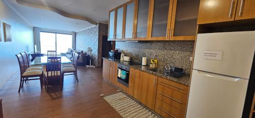 a kitchen and dining room with a table and a refrigerator at Ocean Breeze Apartment in São Vicente