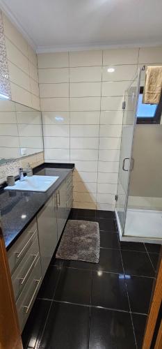 a large bathroom with a sink and a shower at Ocean Breeze Apartment in São Vicente