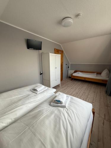 a bedroom with a large bed with white sheets at Strandgut- die Kleine in Dranske