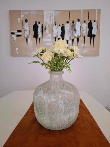a vase with flowers on a table in a museum at Duplex Villa Capricia appartement met zwembad Nieuwpoort Jachthaven in Nieuwpoort