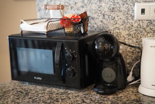 a microwave sitting on a counter with a radio at Ocean Breeze Apartment in São Vicente