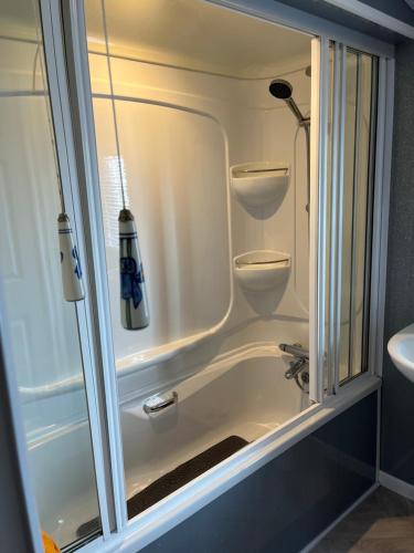a bathroom with a shower and a tub and a sink at West Cumbria static caravan in Workington