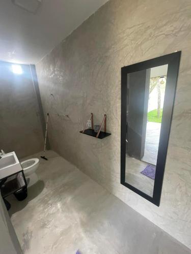 a bathroom with a toilet and a mirror on the wall at Hopa Shelter Surf House Apartamento in Paracuru