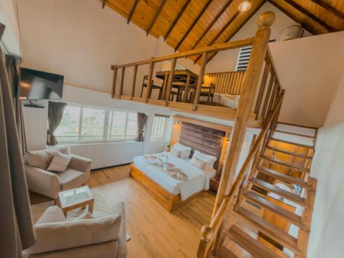 a living room with a loft with a bed and a staircase at Queens Lake Cabin in Nuwara Eliya