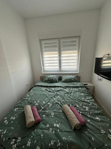a bedroom with a bed with two pillows and a window at Apartman Lady A2 Istočno Sarajevo in Vranješ