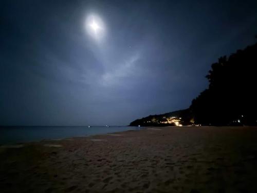 a moonrise over a sandy beach at night at EnDanni Home in Ban Phak Chit