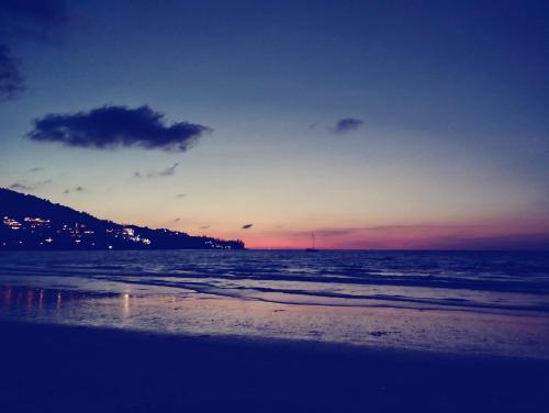 a sunset on the beach with the ocean at EnDanni Home in Ban Phak Chit