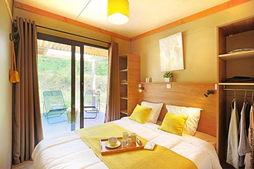 a bedroom with a bed with a tray on it at Camping Les Lavandes in Darbres