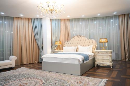 a bedroom with a large bed and a chandelier at Hotel Arai Plaza in Taraz