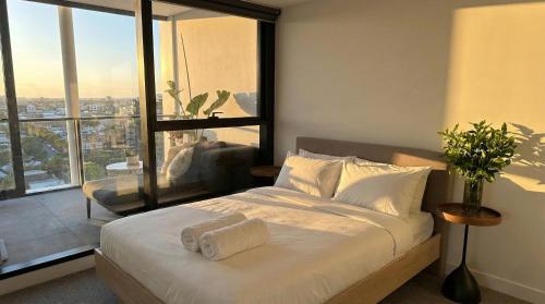 a bedroom with a bed with a view of a city at Domain House Executive in Melbourne