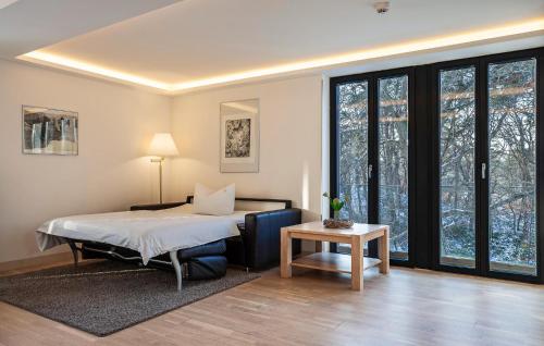 a bedroom with a bed and a table and windows at Garden Suite in Binz