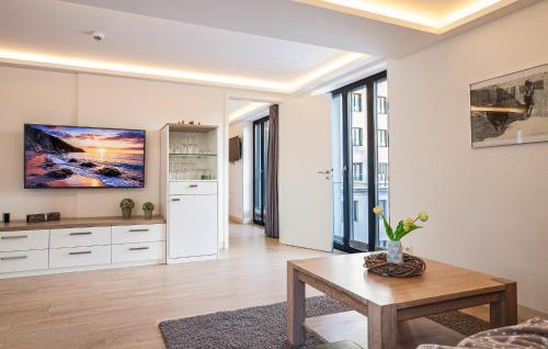 a living room with a table and a kitchen at Garden Suite in Binz