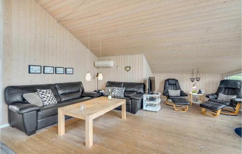 a living room with black leather furniture and a table at Amazing Home In Tarm With Sauna in Tarm
