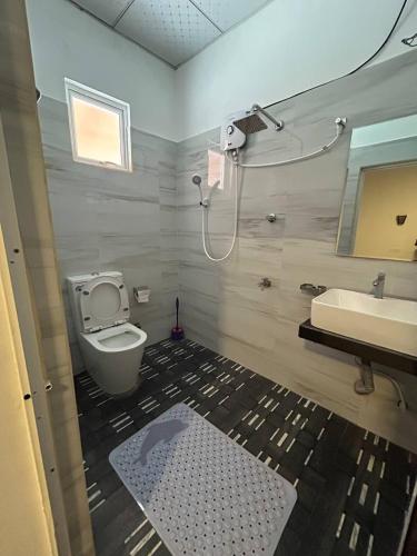 a bathroom with a toilet and a sink at Looma House Hiriketiya in Dickwella